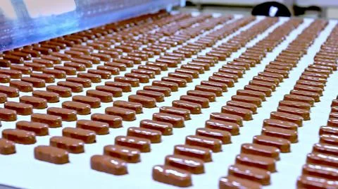 Conveyor with passing chocolate bars. Foto stock