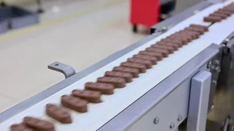 Conveyor with passing chocolate bars. Stock-Fotos