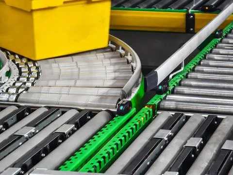 Conveyor system transporting yellow box along rollers in warehouse during d.. Stock Photos