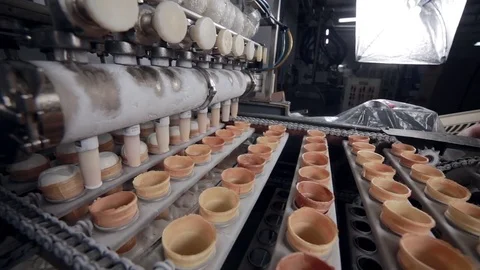 The conveyor transporting the ice-cream cones to the filling machine. Close-up Video stock 75347070