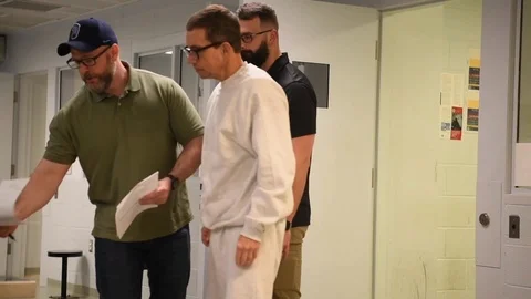 Convicted murderer Jens Soering signs paperwork for ICE Officers 库存影片 122372887