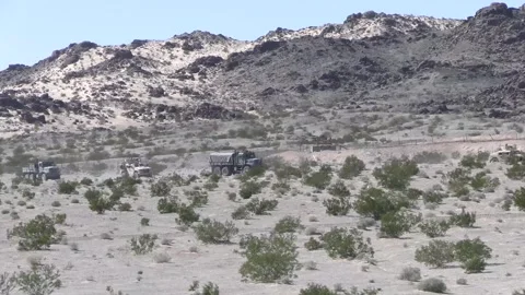Convoy of U.S. Marines Medium and Light Tactical Vehicles driving through desert Stock Footage 266893961