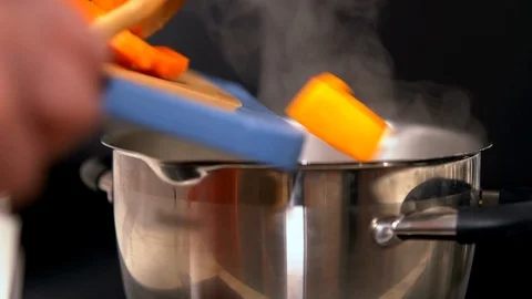 Cook adding diced butternut or pumpkin to a pot Video stock 105861777