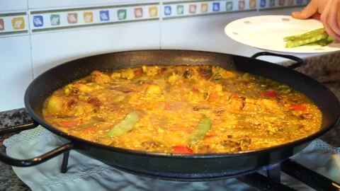 Cook adding the fried peas to the rice about to cook Stock Footage 147988767