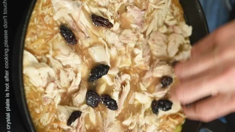 The cook adding raisins to the chicken pilaf. Vertical video. Stock Footage 311046178