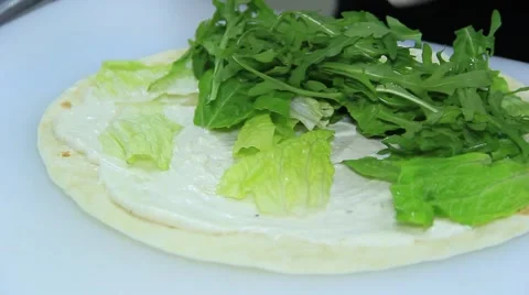 Cook is adding salad and cucumber on tortilla Stock Footage 48397913