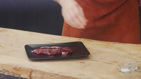 Cook adding salt and pepper on the beef to be roasted Stock Footage 146791857