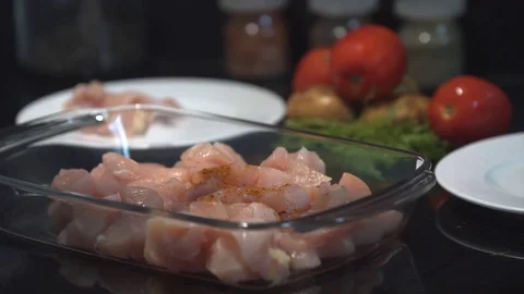 The cook adding spices with a spoon on the top of raw chicken breast, chef cooks 動画素材 82592450