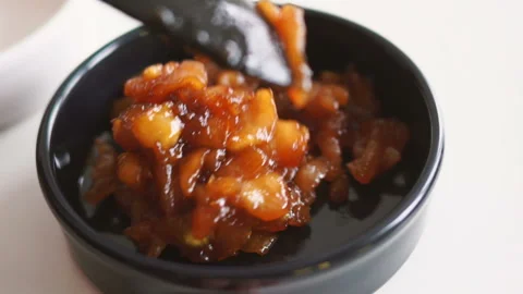 Cook adds apple puree into cake mix in black bowl while baking apple crumble pie Stock Footage 128587213