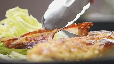 The cook adds bacon to baked Caesar chicken. Stock Footage 150890402