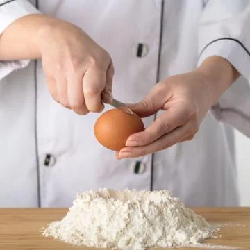 Cook adds an egg Stock Photos