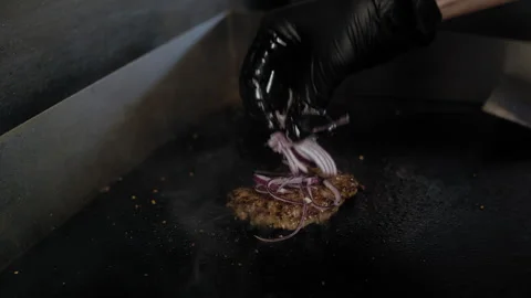 Cook Adds Onions to Juicy Sizzling Burger Patty Video stock 307063953