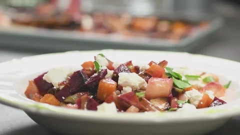 The cook adds parsley on a roasted root vegetables salad. Stock Footage 159908486