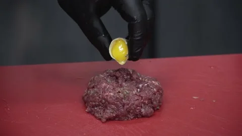 The cook adds a raw egg to the tartare Stock Footage