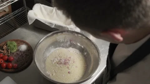 The cook adds a red clover in to a bread dough. Vegetables in a backgraund. 4k Stockbeeldmateriaal 139151471