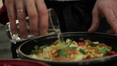 The Cook adds water in the dish Video stock 83067974