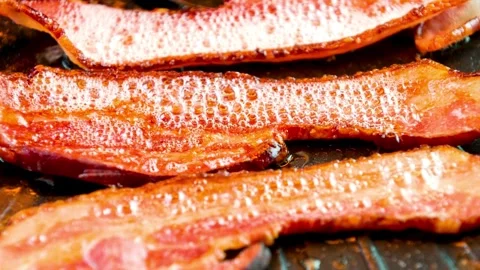 Cook and prepares bacon strips for eating in closeup. 스톡 동영상 334641589