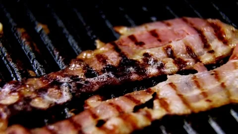 Cook and prepares bacon strips for eating in closeup. 스톡 동영상 334641635