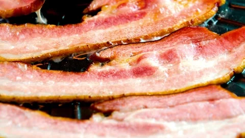 Cook and prepares bacon strips for eating in closeup. 스톡 동영상 334641736
