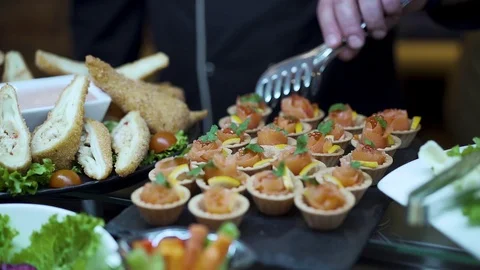 The cook arranges a table with snacks takes a basket of red fish Stock Footage 126120102