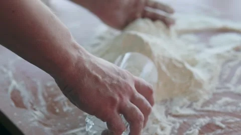 A cook in a bakery kitchen pours flour into a measuring cup. Stock Footage 301287796