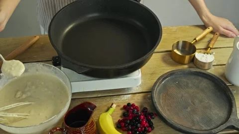 Cook begins baking process by adding flour and egg mixture to pan, along with Stock Footage 304138257