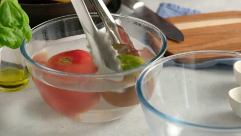 The cook blanch tomatoes with cold water. Pouring boiled cold water a tomato Stock Footage 138092495