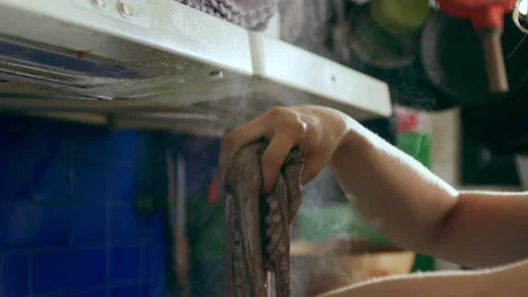 Cook boiling octopus in a large pot under a stove, inside a large well appointed Stock Footage 199455656