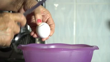 The cook breaks the egg and pours it into a bowl Video stock 85950636