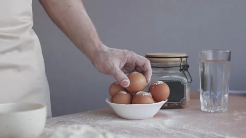 A cook breaks an egg and separates the yolks from the whites. Vídeos de archivo 297656313