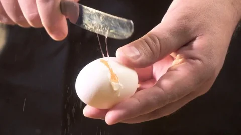 The cook breaks the egg with a knife.Slow motion Stock Footage 76397110
