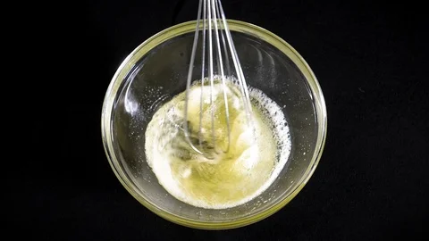 The cook brews the eggs. Whisk egg white. Black background. Slow motions Stock Footage 86551475