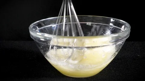 The cook brews the eggs. Whisk egg white. Black background. Slow motions Stock Footage 86551538