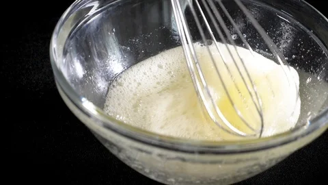 The cook brews the eggs. Whisk egg white. Black background. Slow motions Stock Footage 86551603