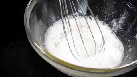 The cook brews the eggs. Whisk egg white. Black background. Slow motions Stock Footage 86551647