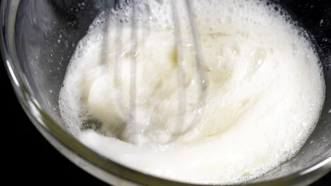 The cook brews the eggs. Whisk egg white. Black background. Slow motions Stock Footage 86551726