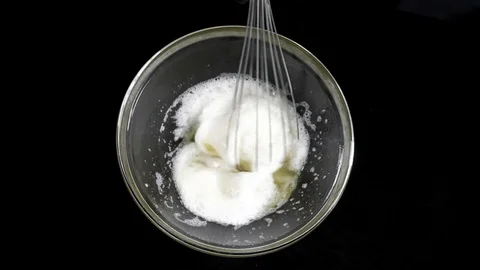 The cook brews the eggs. Whisk egg white. Black background. Slow motions Stock Footage 86551813