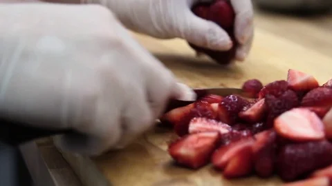 Cook carefully cuts strawberries Stock Footage 70004383