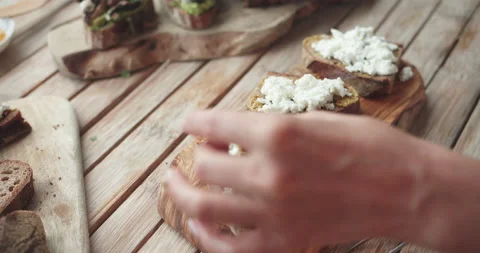 Cook chef cuts the olive and puts it on the bruschetta with cheese on a wooden Stock-Footage 141654544