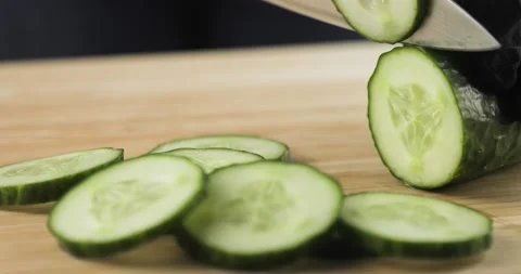 Cook chef in gloves cutting the cucumbers into slices, closeup view. Stock Footage 147346539