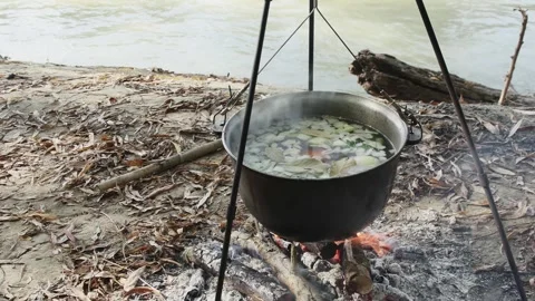 Cook classic fish soup in a cauldron on a fire in nature near the river Vídeos de archivo 257044779