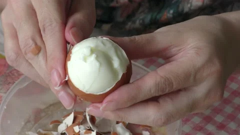 A cook cleans a boiled chicken egg with his hands Stock Footage 156669920