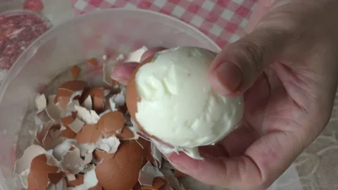A cook cleans a boiled chicken egg with his hands Stock Footage 156670014