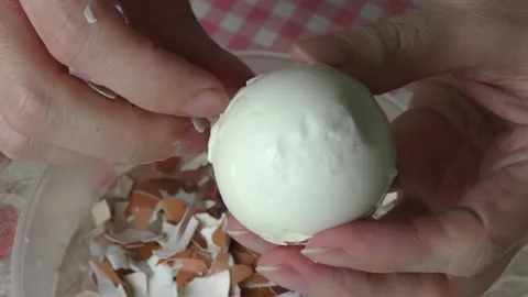 A cook cleans a boiled chicken egg with his hands Stock Footage 156670951