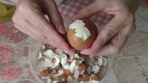A cook cleans a boiled chicken egg with his hands Stock Footage 156672376