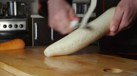 Cook cleans a daikon in a restaurant kitchen Stock Footage 63216174