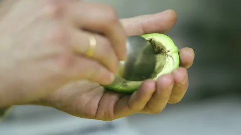 Cook cleans the mango with a spoon. Hands close up Stock Footage 104770953