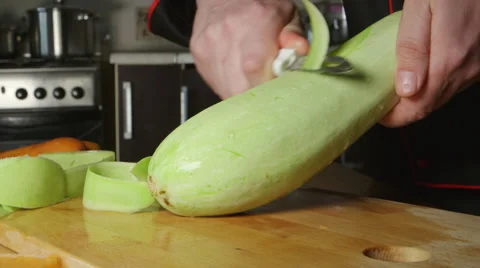 Cook cleans a vegetable marrow on a cutting board Stock Footage 63216186