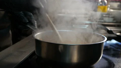The cook is cooking dinner in the kitchen. Black gloves on hand Stock Footage 127429280