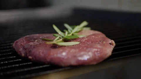 The cook cooks the meat in the kitchen a chop on the grill the stove Video stock 142036022